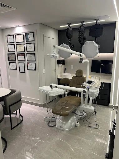 Sala clínica com cadeira odontológica e equipamentos modernos